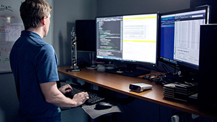 소프트웨어 개발자가 책상 위 컴퓨터에서 Azure Kinect DK에 타이핑하고 있다.