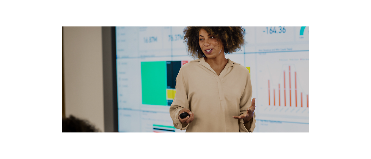 A woman is giving a presentation in front of a large screen.