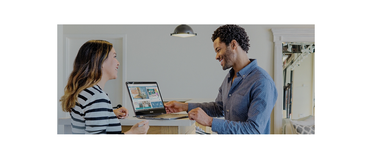 A man and woman looking at a laptop in a home.