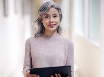 A girl is standing with a tablet.