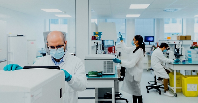 People wearing protective masks working in a lab 