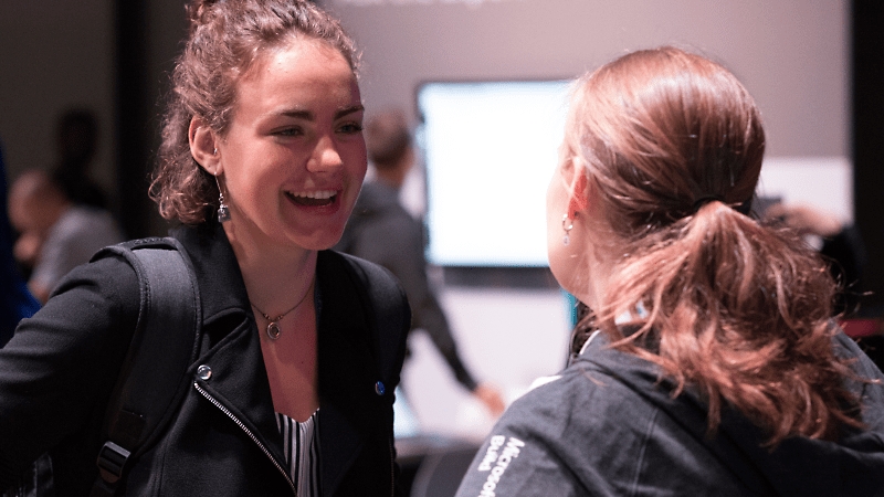 Two students having a conversation and smiling.