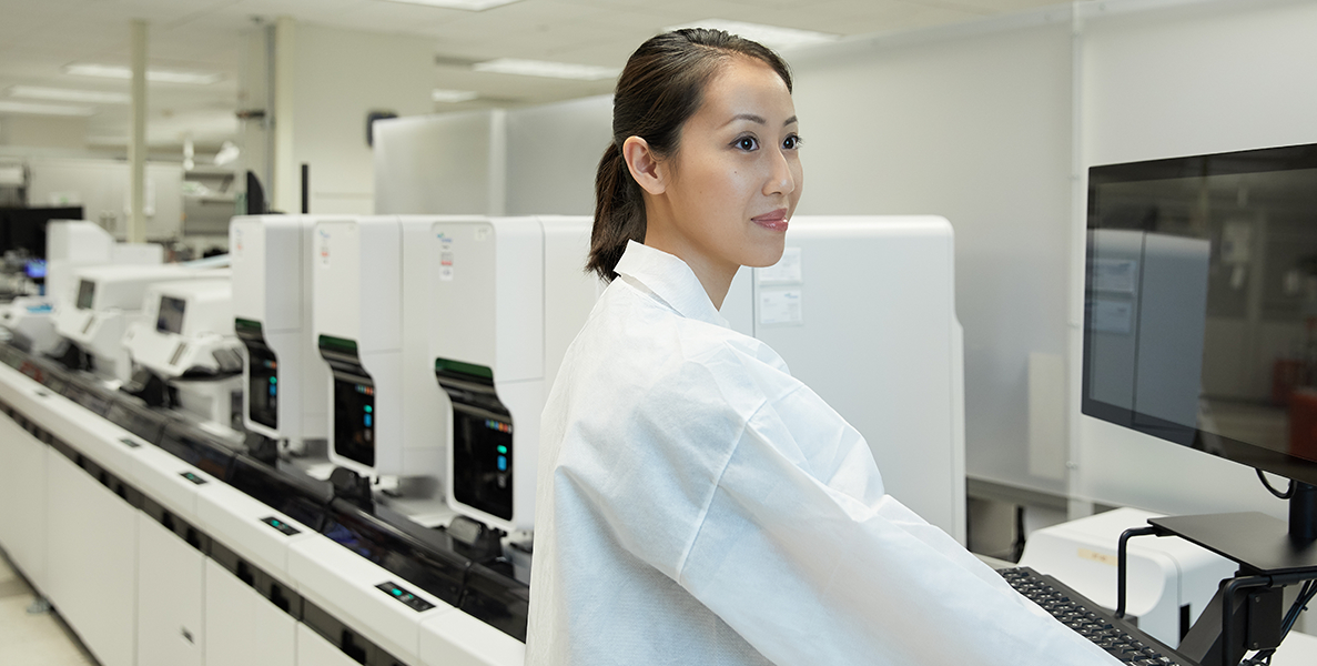 Female laboratory professional in front of state-of-the-art laboratory equipment