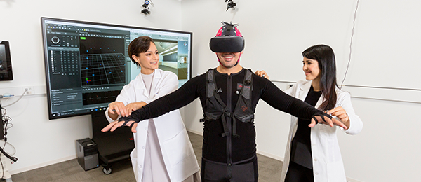 Two female researchers working with man wearing state-of-the-art virtual reality headset