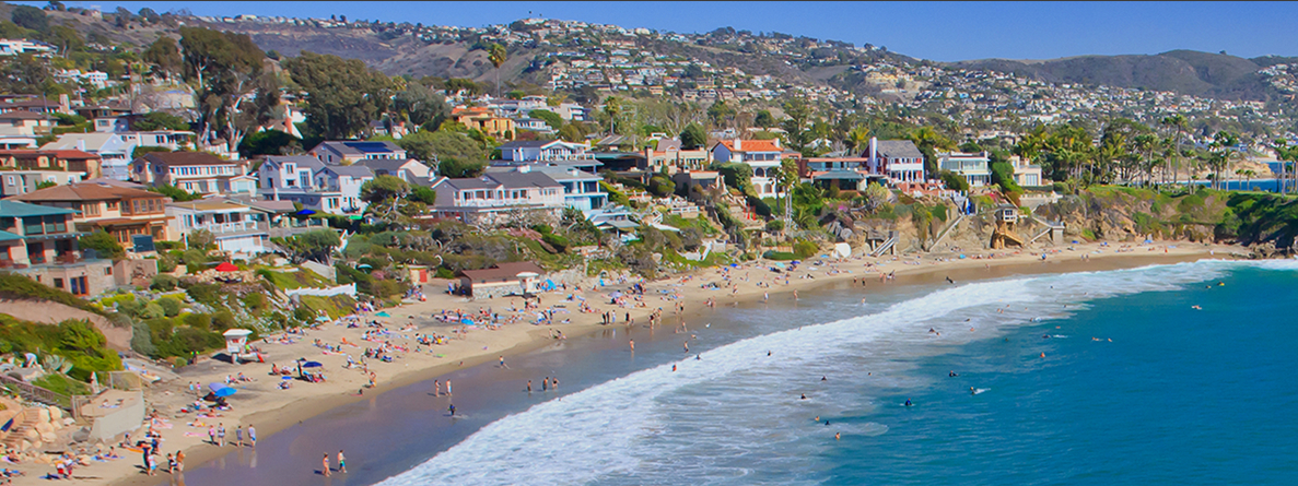 Aerial photo of people playing on beach with houses along the shoreline