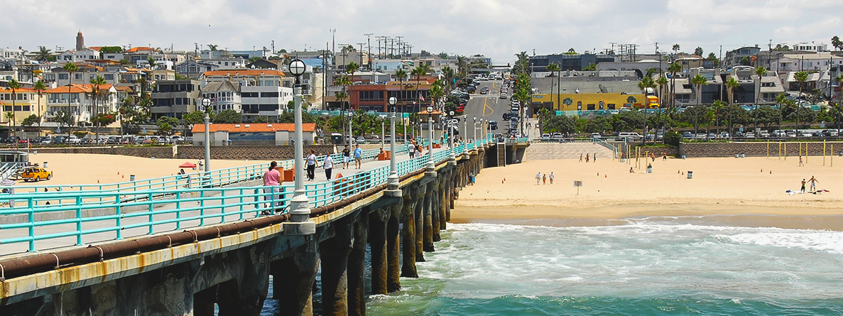 Looking down long pier toward the beach and neighboring beachside town