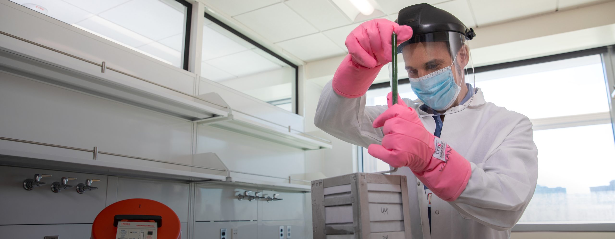 A male UCLA Health research professional working with laboratory samples within a UCLA Health laboratory setting