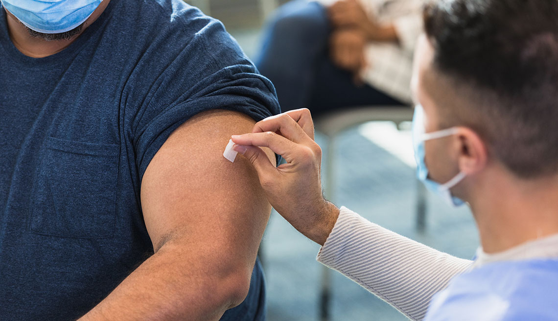 doctor uses an alcohol swab to prepare the injection site of the patient's arm