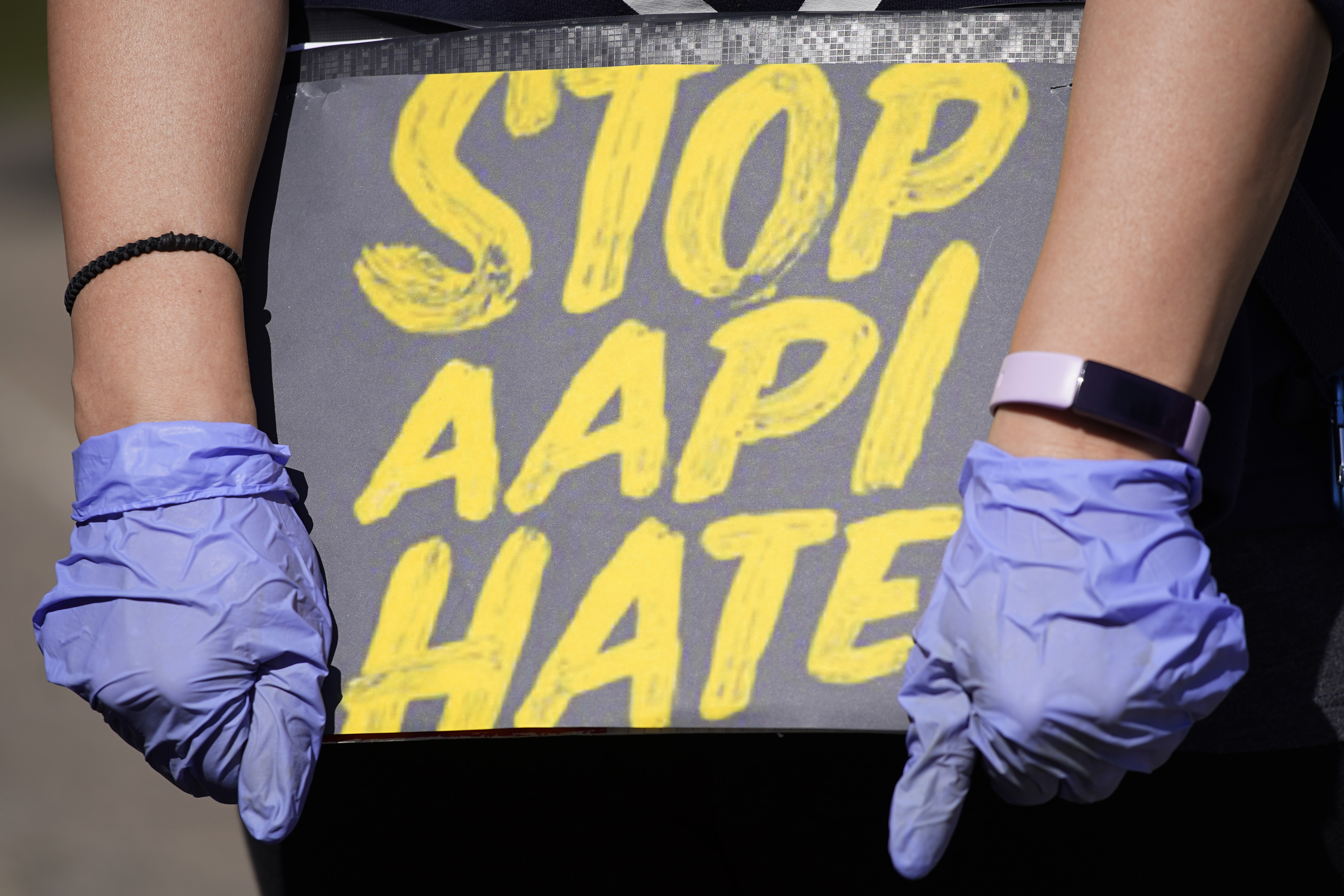 Woman holds a sign and attends a rally to support stop AAPI (Asian Americans and Pacific Islanders) hate at the Logan Square Monument in Chicago, Saturday, March 20, 2021.