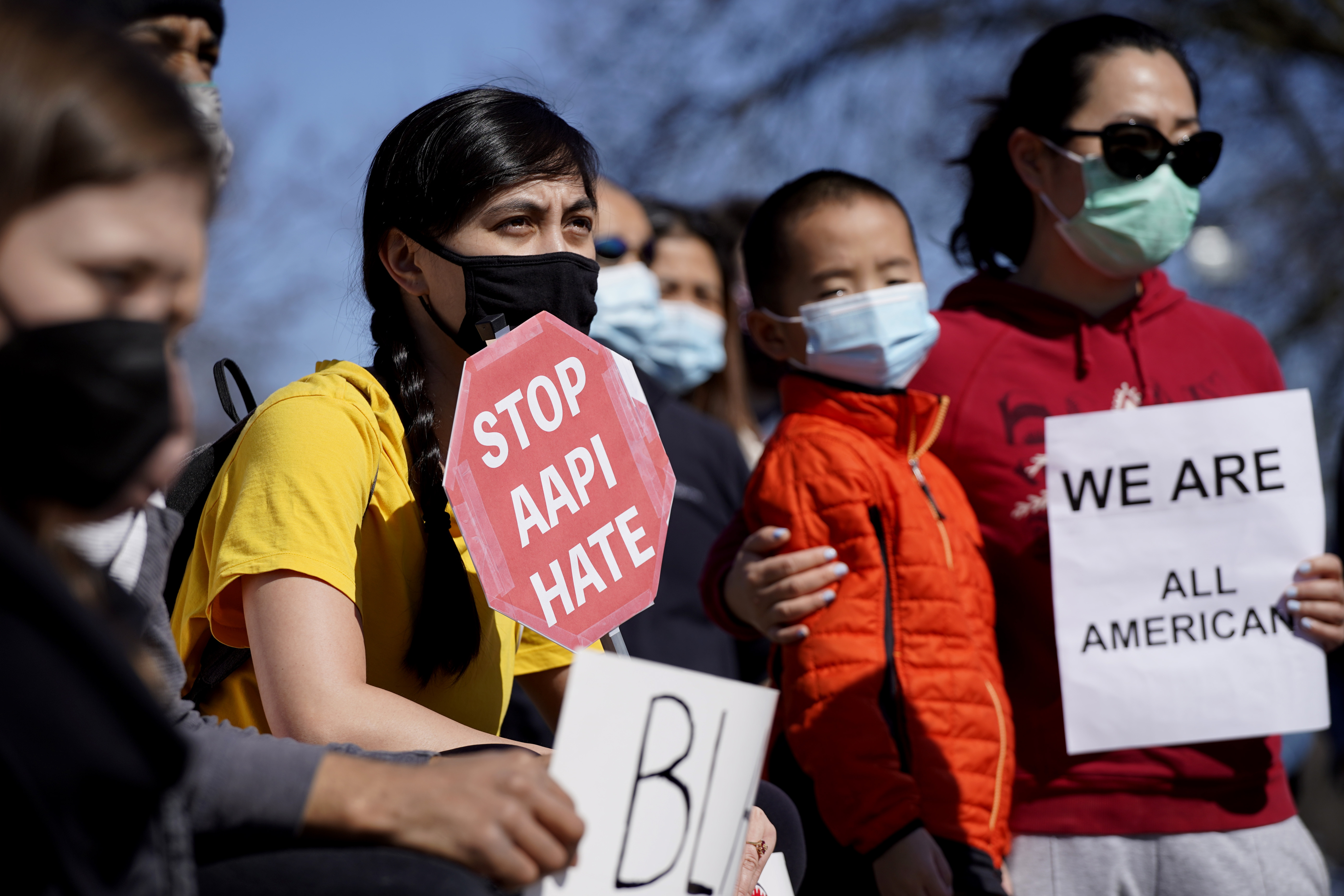 People hold signs as they attend a rally to support Stop Asian Hate at the Logan Square Monument in Chicago, Saturday, March 20, 2021.