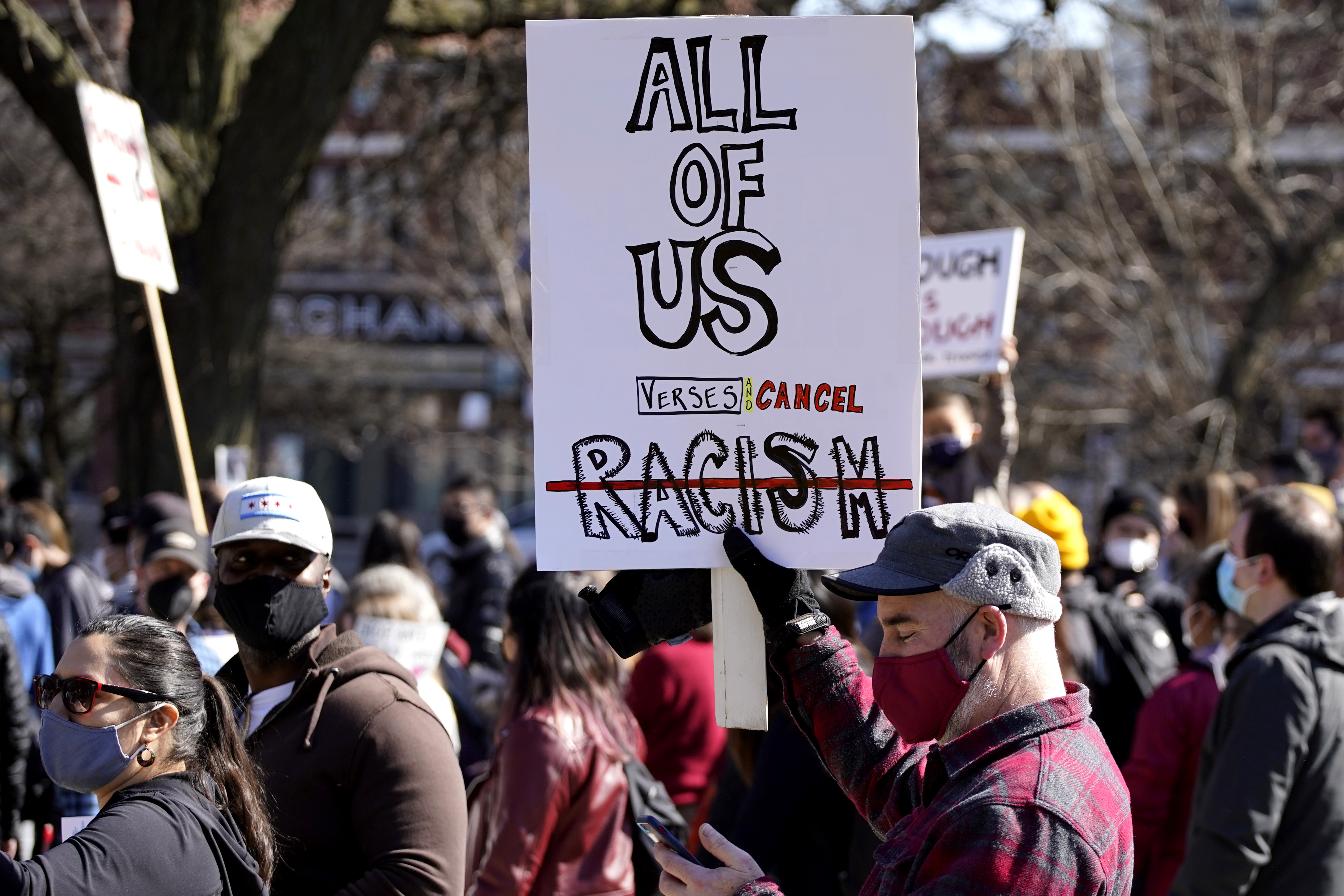 People hold signs as they march during a rally to support Stop Asian Hate at the Logan Square Monument in Chicago, Saturday, March 20, 2021.