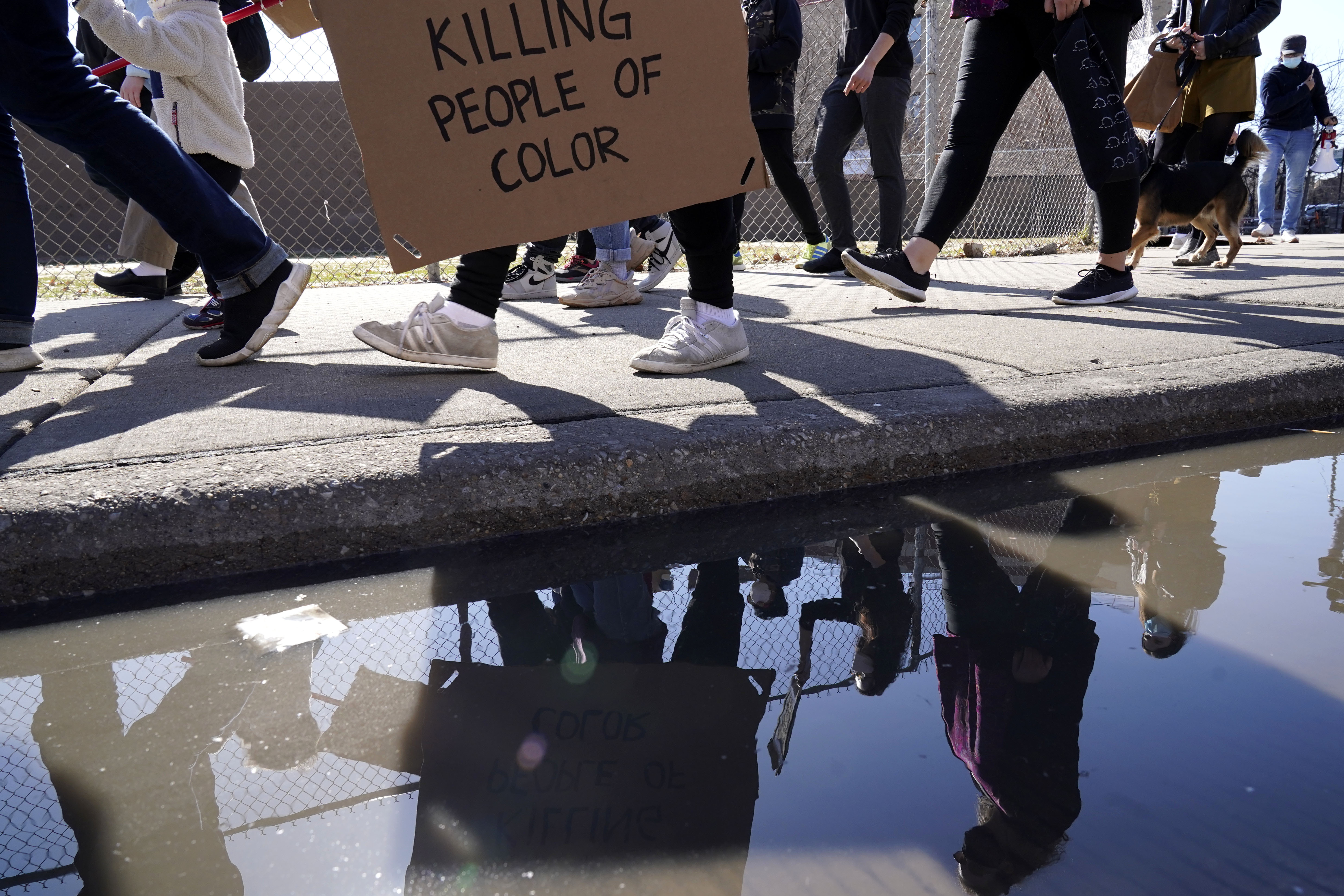 People hold signs as they march for a rally to support Stop Asian Hate at the Logan Square Monument in Chicago, Saturday, March 20, 2021.