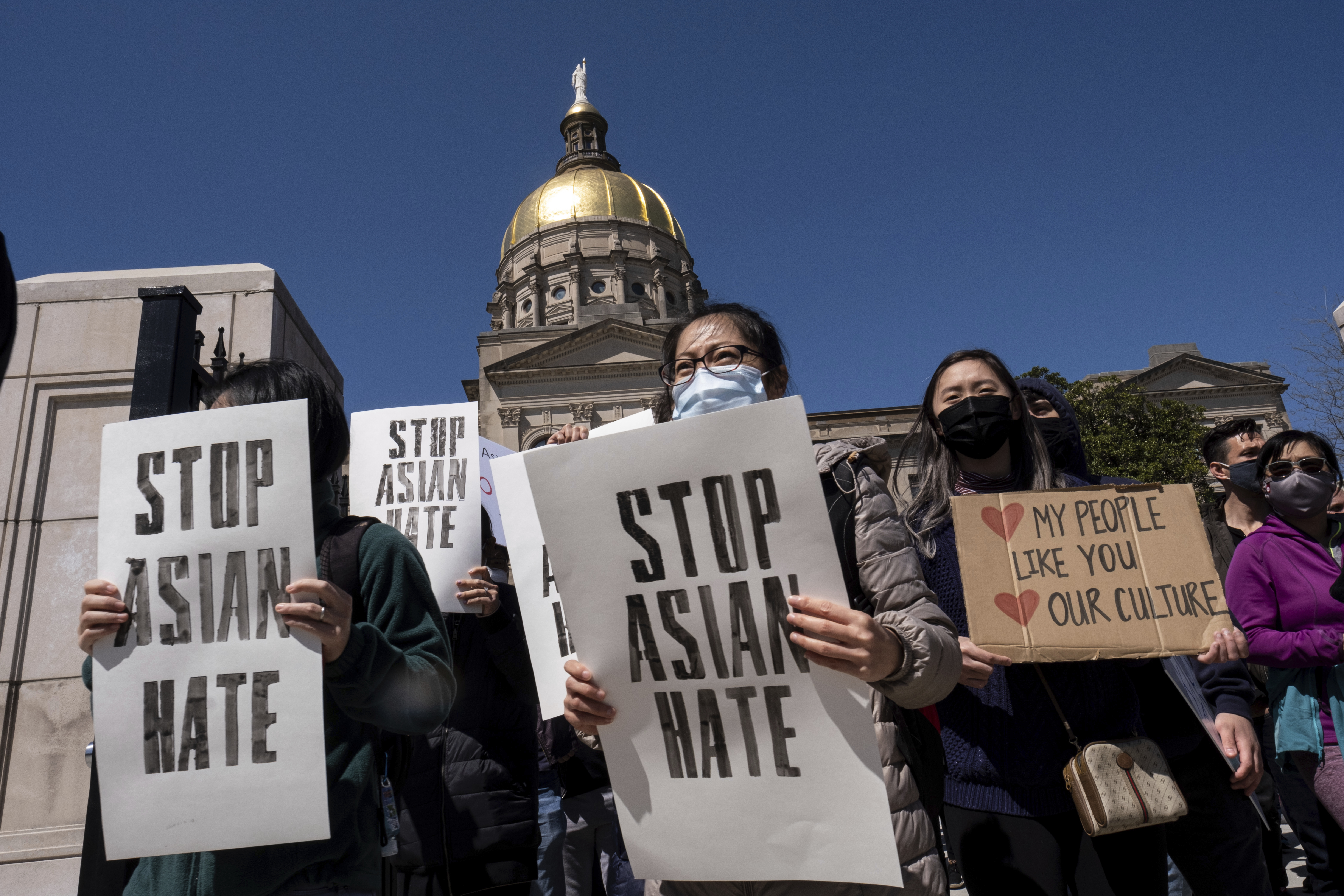 People hold signs while participating in a "stop Asian hate" rally outside the Georgia State Capitol in Atlanta on Saturday afternoon, March 20, 2021.