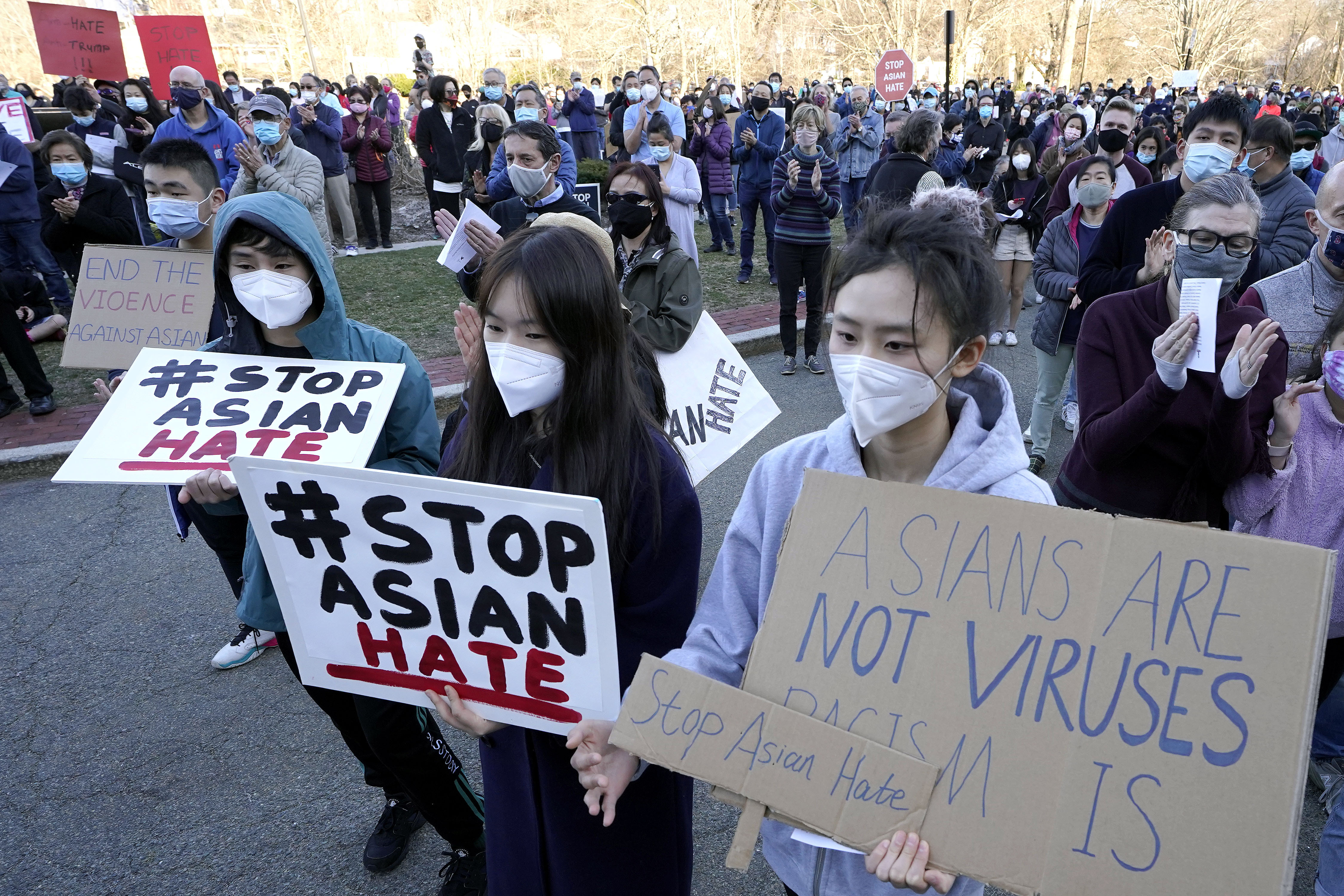 Protesters Dana Liu, center front, and Kexin Huang, right, both of Newton, Mass., display placards during a rally to support Stop Asian Hate, Sunday, March 21, 2021, in Newton.