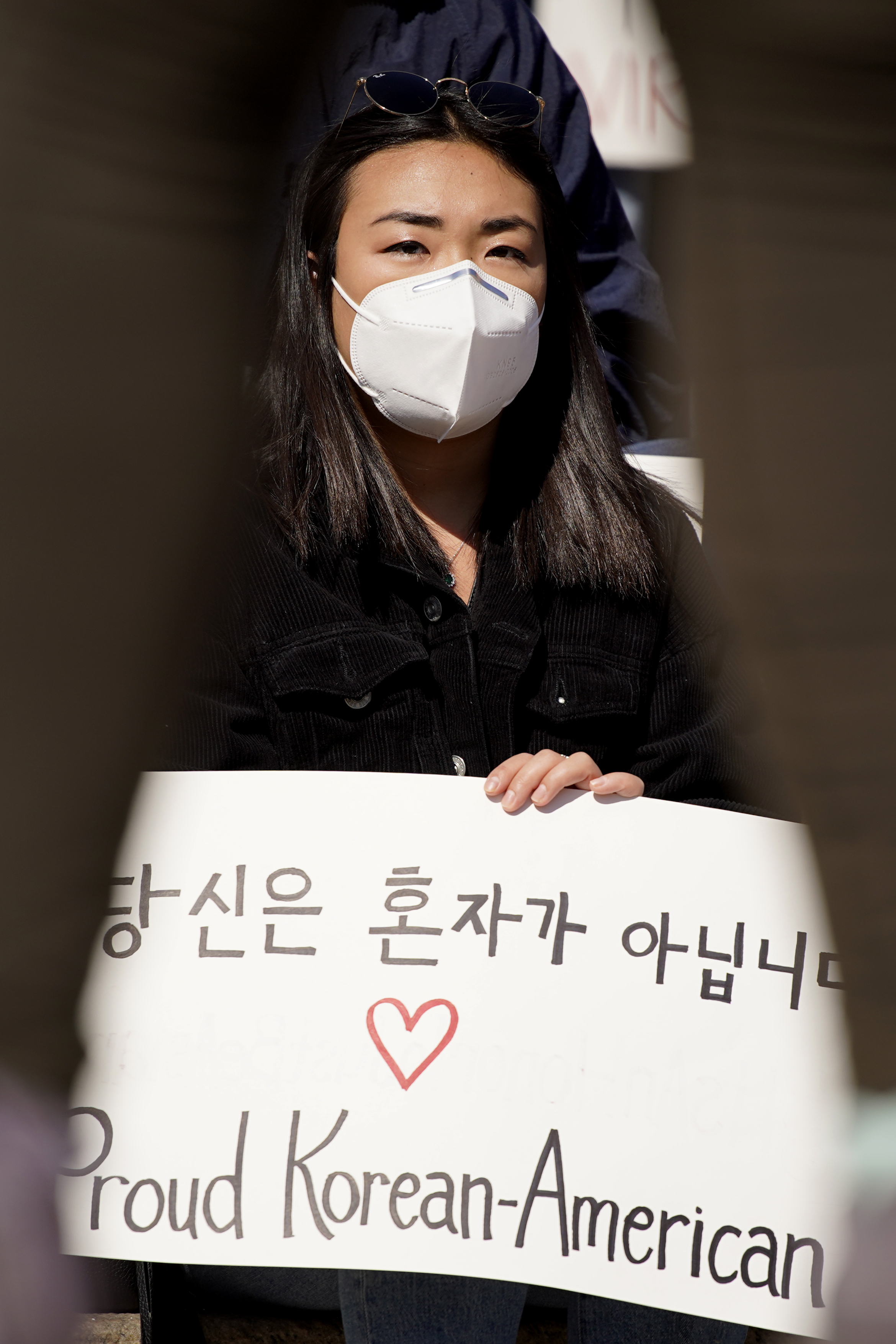 Sophia Sim holds a sign as she attends a rally to support Stop Asian Hate at the Logan Square Monument in Chicago, Saturday, March 20, 2021.