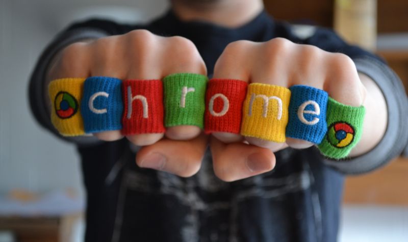 A man wears soft rings that spell out CHROME.