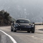 A person drives a Lotus Emira on a mountain road