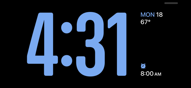 A digital clock with weather and alarm info