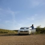 A BMW neue klasse concept in the desert, with a door open