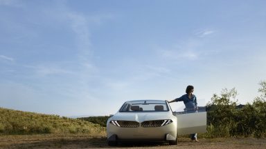 A BMW neue klasse concept in the desert, with a door open