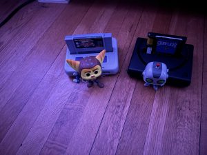 Two video game figurines beside consoles