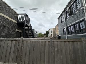 A fenced yard in a Chicago neighborhood with overcast skies