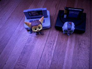 Two video game figurines beside consoles