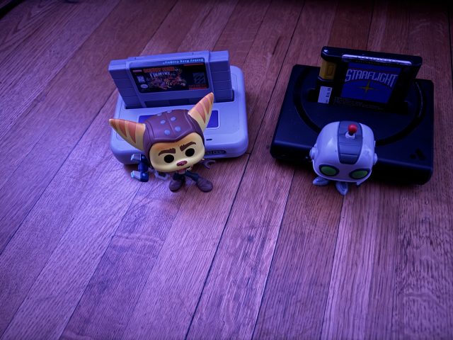 Two video game figurines beside consoles