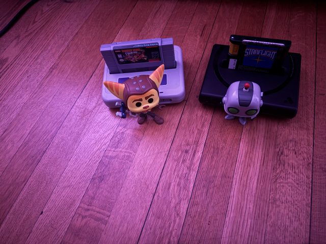 Two video game figurines beside consoles