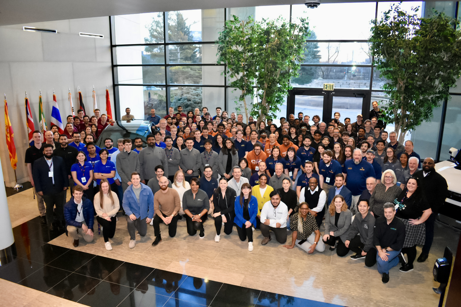 Lots of people all pose for a photograph in an atrium