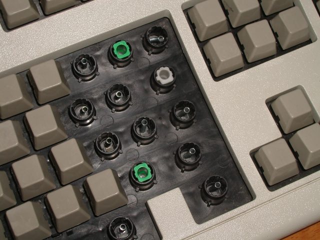 A Model M keyboard with switches and stabilizers visible.