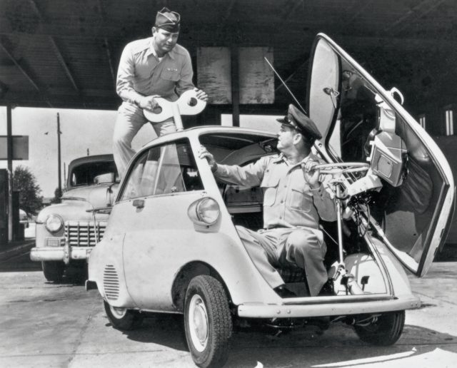 A black and white photo of an Isetta bubble car