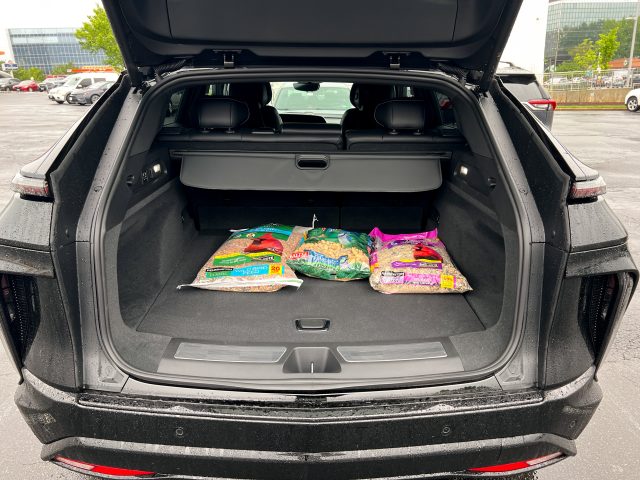 A cadillac lyriq trunk with three bags of bird seed