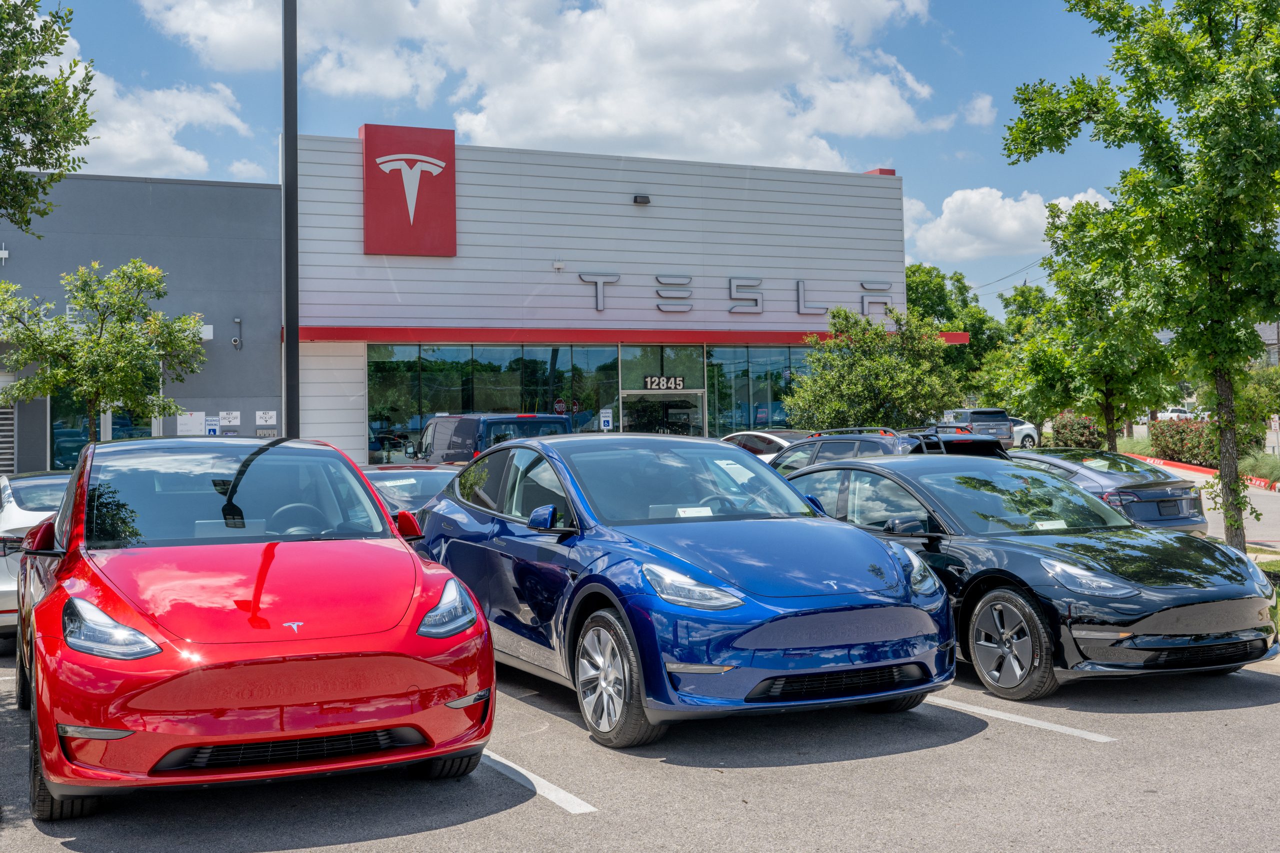 Three Tesla Model Ys outside a Tesla shop in Texas