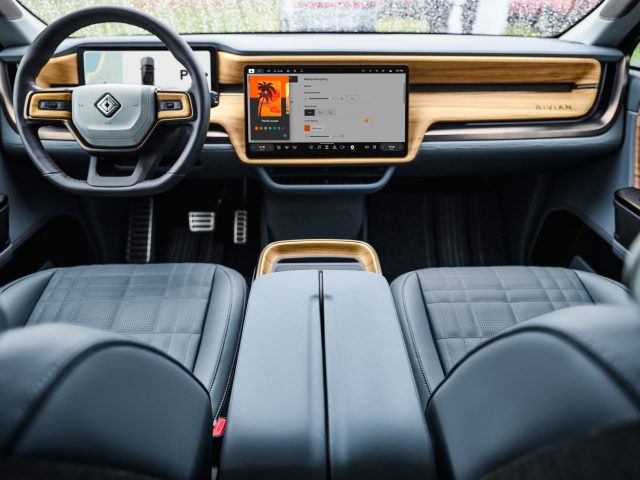 A Rivian interior with blue seats and wood trim