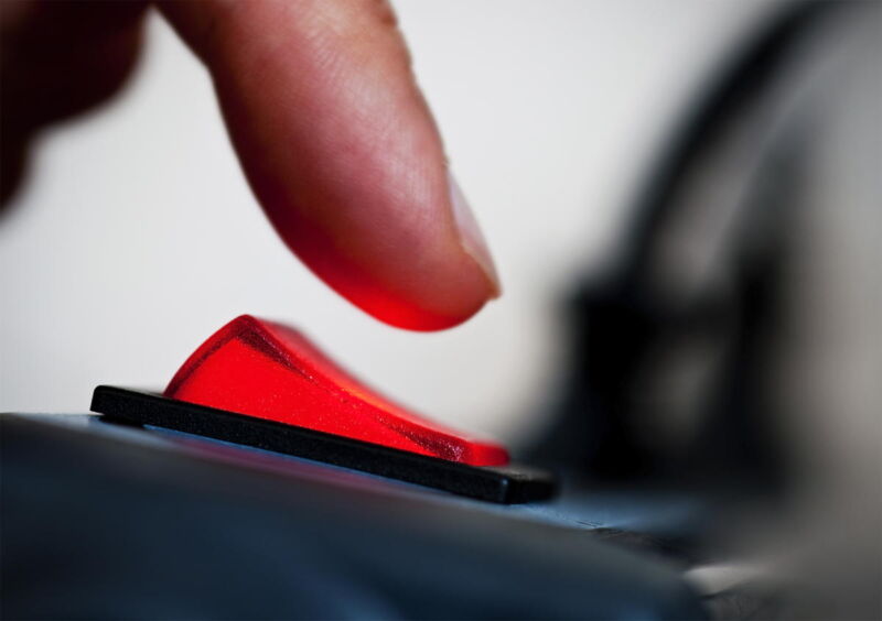 A finger poised over an electrical switch.