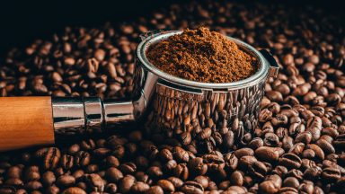 Close-up of coffee beans with roasted beans on table