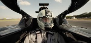 closeup of F1 driver in helmet in the driver's seat