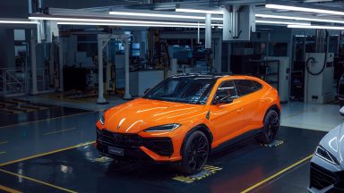 An orange lamborghini Urus at the factory