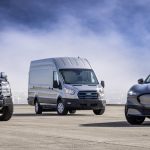 A ford F-150 Lightning, E-Transit, and Mustang Mach-E parked in a row