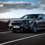 A BMW M5 Touring drives through a volcanic landscape