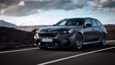 A BMW M5 Touring drives through a volcanic landscape