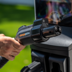 A person holds an EV charging plug