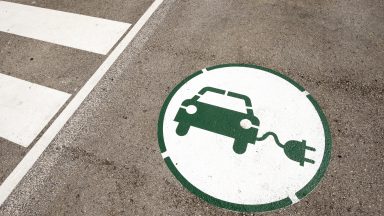 A logo of an EV painted on the ground