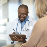 Smiling doctor discussing medical results with a woman.