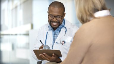 Smiling doctor discussing medical results with a woman.