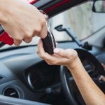 Salesman handling car keys to customer