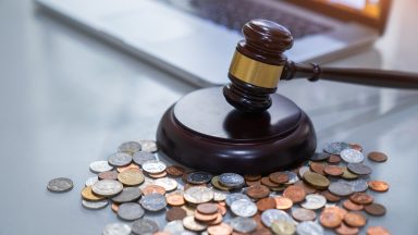 A judge's gavel near a pile of small change.