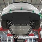 An employee works beneath a Tesla Model X sports utility vehicle (SUV) during assembly for the European market at the Tesla Motors Inc. factory in Tilburg, Netherlands, on Friday, Dec. 9, 2016. A boom in electric vehicles made by the likes of Tesla could erode as much as 10 percent of global gasoline demand by 2035, according to the oil industry consultant Wood Mackenzie Ltd. Photographer: Jasper Juinen/Bloomberg via Getty Images