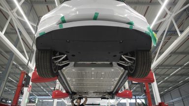 An employee works beneath a Tesla Model X sports utility vehicle (SUV) during assembly for the European market at the Tesla Motors Inc. factory in Tilburg, Netherlands, on Friday, Dec. 9, 2016. A boom in electric vehicles made by the likes of Tesla could erode as much as 10 percent of global gasoline demand by 2035, according to the oil industry consultant Wood Mackenzie Ltd. Photographer: Jasper Juinen/Bloomberg via Getty Images